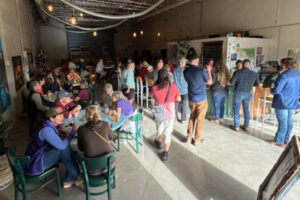 People sitting and standing inside Open Space Brewing to help kick off the first celebration of Trail Days.