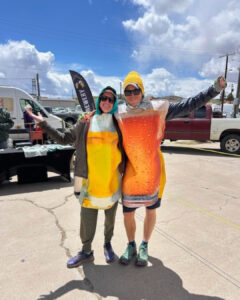 A couple stand in Open Space Beer Garden wearing beer glass costumes to help promote their friends' brewery.