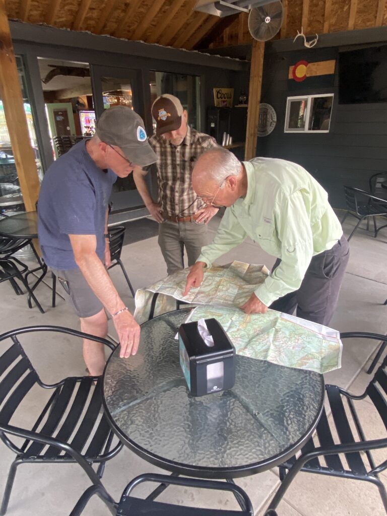 Three men looking at trail maps